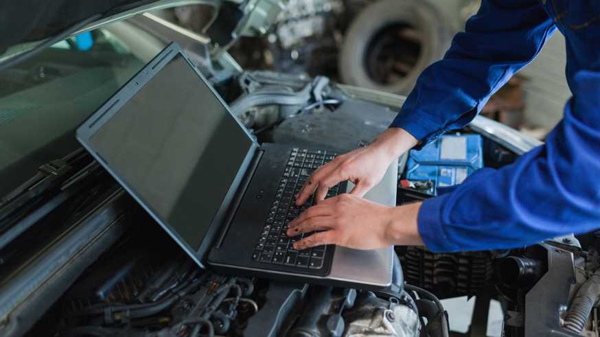 Close-up of auto mechanic using laptop