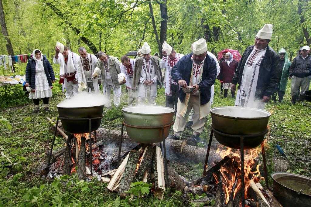 Мужчины готовят еду в священной роще